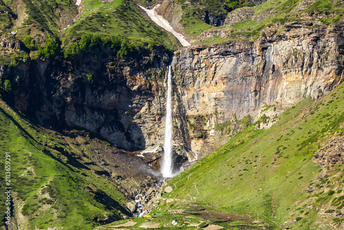 Sissu Waterfall wide landscape view plunging down rocky cliff into lush green Himalayan valley in Lahaul Himachal Pradesh