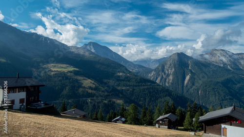 Fotografie Breathtaking panoramic view of traditional alpine chalets and majestic mountain peaks in Rosswald above the Rhone Valley, Valais, Swiss Alps