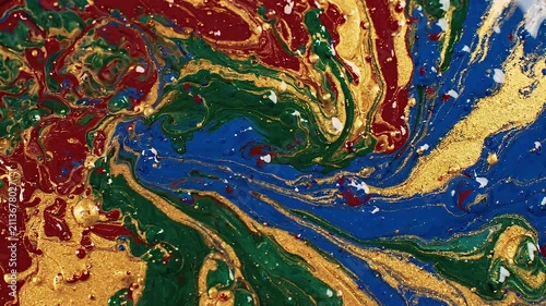 Abstract macro background of swirling gold blue red and green liquid paint texture swirl color marble