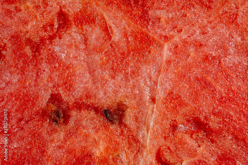 Macro closeup of ripe watermelon flesh with embedded black seeds