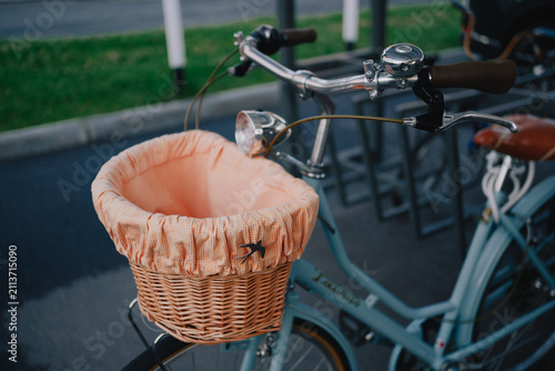Vintage city bicycle with wicker front basket parked outdoors in urban bike parking area