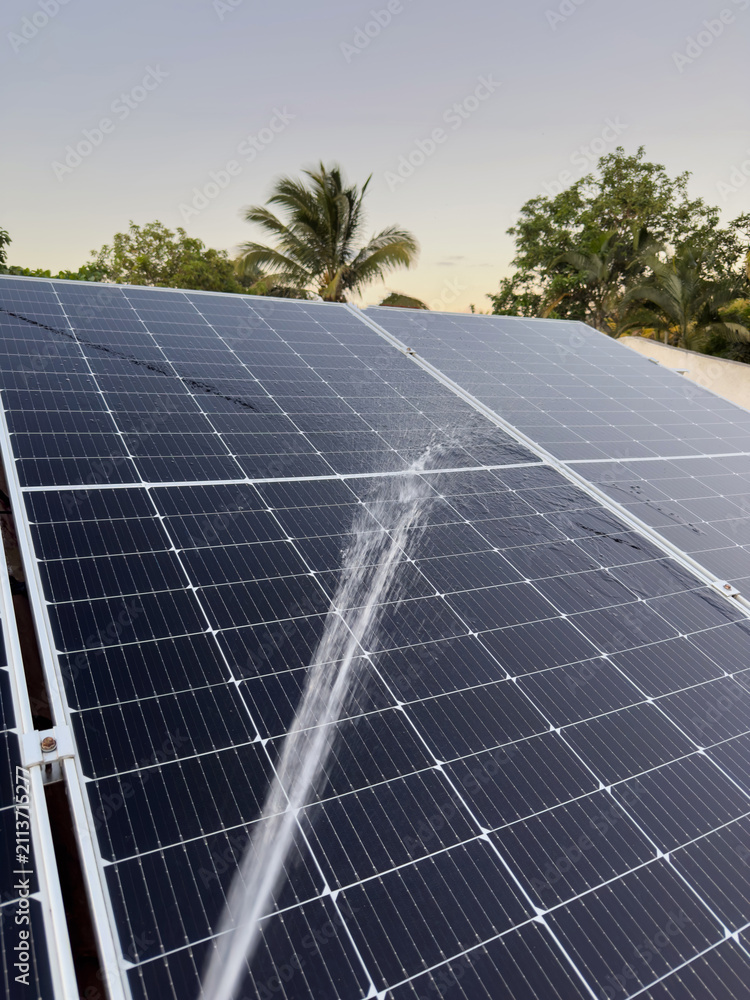 Obraz premium Cleaning solar panels from dust with water spray