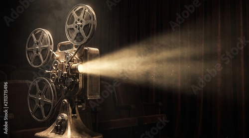 Vintage movie projector casting a beam of light in a dark theater with empty velvet seats