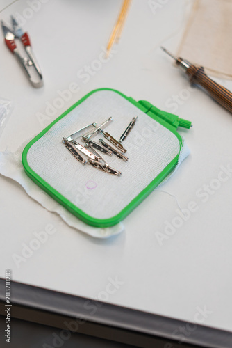 Cuadro en lienzo Embroidery set: hoop, pins, awl on a white table
