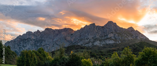 Fényképezés A cinematic mountain panorama of the Picos de Europa under a blazing sky and above verdant valleys, evoking a world of epic fantasy