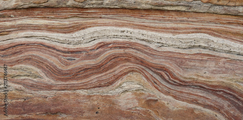 Close up of marble slab with swirling red beige and white mineral veins pattern background abstract interior material architectural polished countertop formation mineralogy artistic