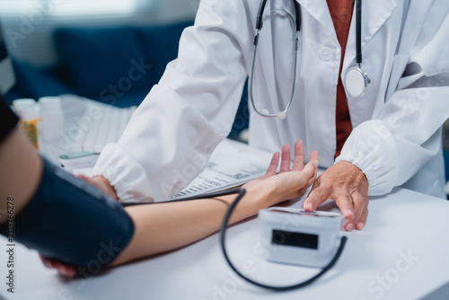 Doctor checking patient's blood pressure during medical consultation