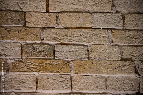 A close-up view of an old, weathered brick wall with visible mortar lines and subtle color variations