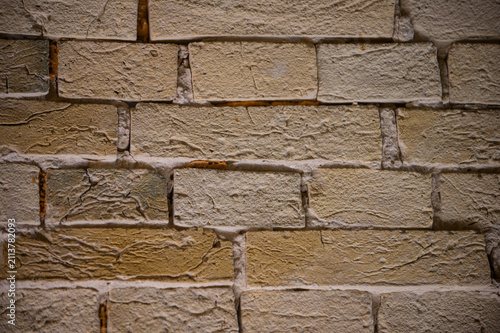 A close-up view of an old, weathered brick wall with visible mortar lines and subtle color variations