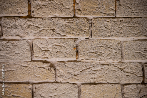 A close-up view of an old, weathered brick wall with visible mortar lines and subtle color variations