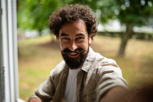 Happy man with beard smiling taking selfie
