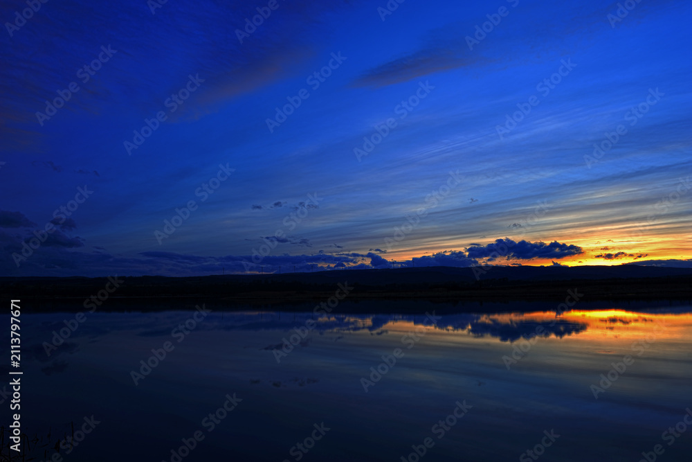 Obraz premium Summer sunset over wheat field. Beautiful sunset sky over countryside