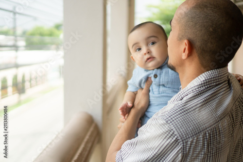 Fotografie Father holding infant baby enjoying family life