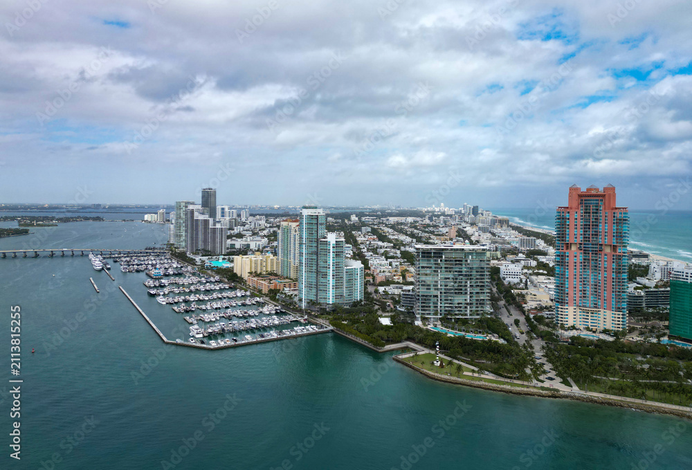 Fototapeta premium Yacht docked at Miami marina. Aerial view of coastline in Miami. Miami skyline above harbor. Famous Miami Beach marine from above. Marina with yachts.