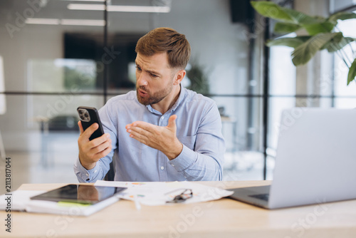 Canvas Print Stressed businessman receiving bad news on phone, showing frustration and annoya