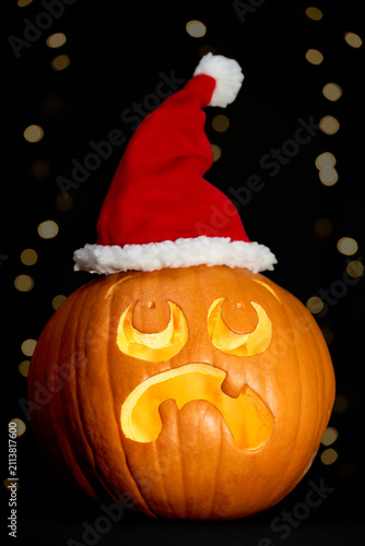 Foto Shocked Carved Halloween Pumpkin Wearing a Santa Hat Illustrating Christmas Cree