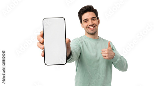 Smiling young man holding smartphone with blank white screen, happy male showing mobile phone mockup and thumbs up gesture, isolated on white background