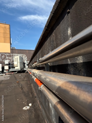фотографія Industrial Metal Conduit Installation on Commercial Rooftop Under Blue Sky