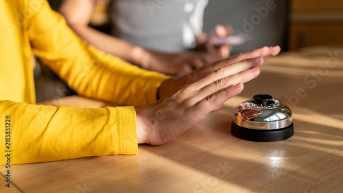 Child Hand Ready to Press Quiz Buzzer. Close-up of a child’s hand hovering above a metal quiz buzzer during a competitive educational game at home.