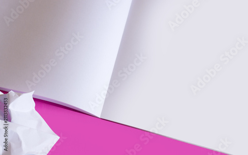 Foto Open drawing album with white pages placed on a bright pink surface next to crumpled paper symbolizing creativity, art lessons, and school preparation