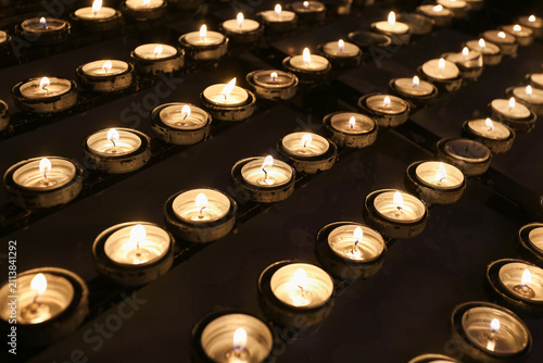 Tableau sur toile Rows of burning tealight candles glow softly