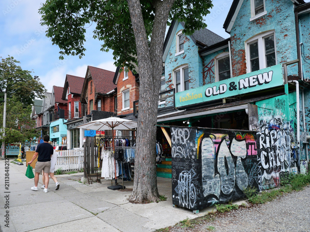 Fototapeta premium Vintage clothing store with outdoor display on sidewalk, Kensington Market bazaar, Toronto