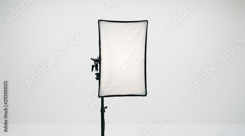 A rectangular softbox light modifier on a stand, creating diffused light, ideal for studio photography setups and visual presentation
