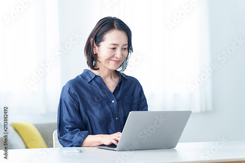 自宅でデスクワークをする中高年女性