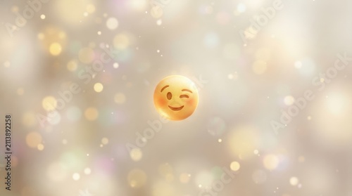 Winking emoji face glowing on a soft warm bokeh background representing happiness and positive communication concepts