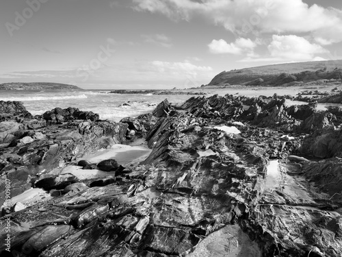 Landscape views of rocks and ocean from beaches along the Victor Harbor Heritage Trail on the Fleurieu Peninsula in South Australia in black and white