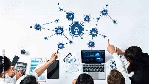 Canvastavla A team collaborates in a modern office space to analyze data and strategize for business growth, showcasing technology, graphs, and creative planning tools for effective decision making
