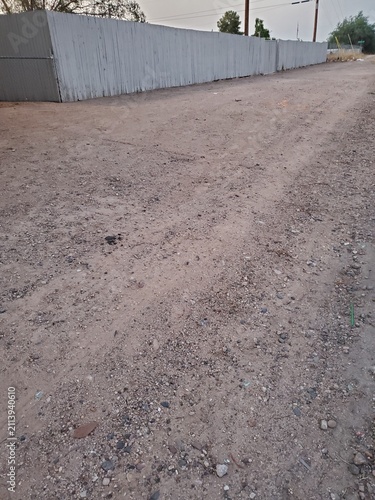 Gravel Dirt Road Texture on Ground of Alley Near Fence