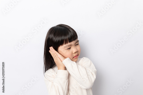 Konstfotografi A little girl pretending to sleep against a white background