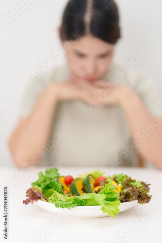 Unhappy woman disgust gesture and Bored to eat fresh organic vegetables. healthy nutrition, weight loss, clean eating, Healthy food eating, Vegan, Wellness, Green dieting and Healthy lifestyle