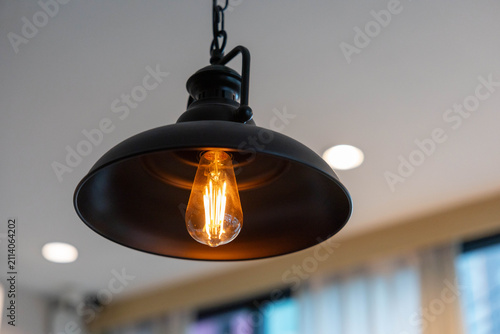 Obraz na plátně Classic industrial lamp with exposed bulb illuminates dim room