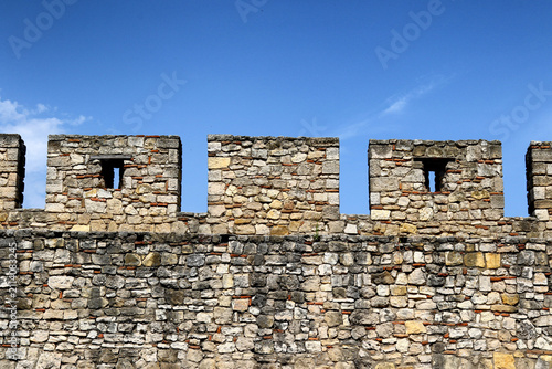 Photography Stone battlement wall with embrasures at Kalemegdan Fortress under a clear blue