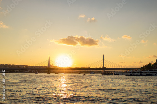 Canvastavla Scenic view of the Golden Horn in Istanbul, Turkey, during sunset, with a bridge, calm waves and warm golden colors across the sky and water