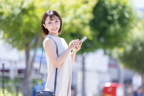 街でスマホを持つ若い女性