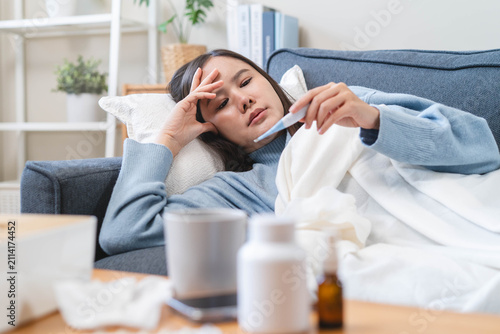 Принти на полотні Sick person resting in bed checking temperature with thermometer, suffering from