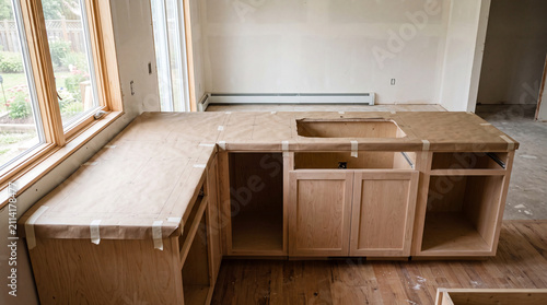 Paper countertop template laid across kitchen cabinet boxes before fitting