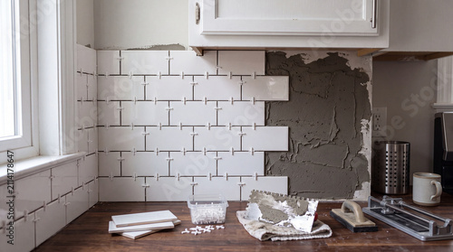 Backsplash tiling half finished with spacers still set in the joints