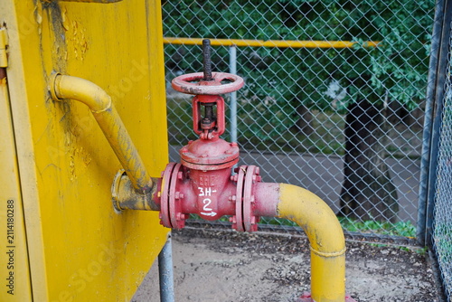 Yellow pipes and a red valve for regulating the supply of household gas to homes.