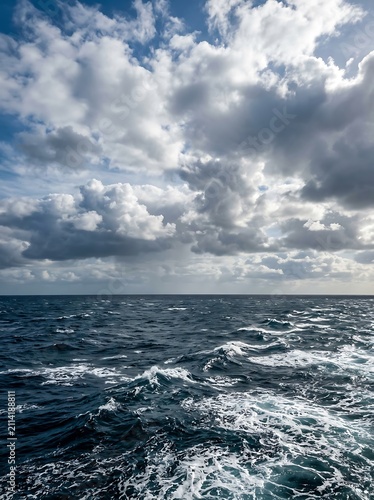Dramatic stormy ocean waves under cloudy sky.
