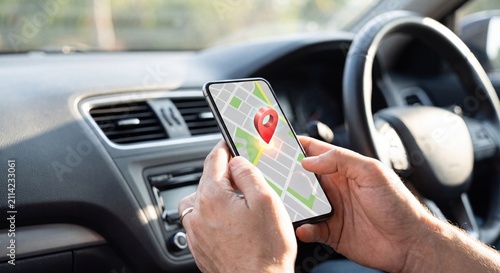 Person using mobile phone navigation app while sitting inside modern vehicle driver seat interior with holding smartphone with smartphone