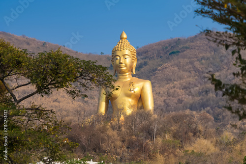Golden Buddha Statue Overlooking Valley: A magnificent golden Buddha statue, an icon of peace and enlightenment, stands majestically on a hilltop.