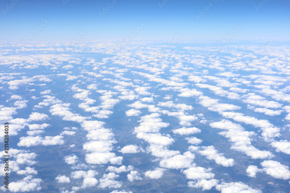 Fototapeta premium Aerial view of a vast field of white cumulus clouds under a clear blue sky