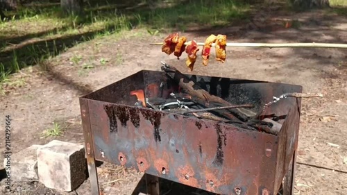 Raw meat on skewers rests over an open flame