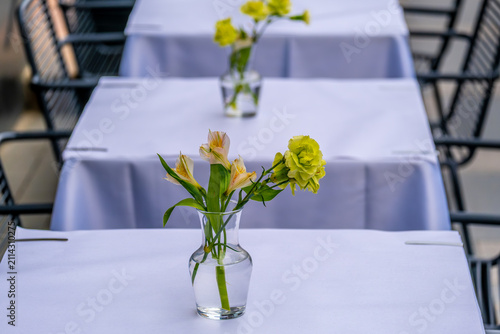Flowers in a vase on a table on the veranda of a summer cafe.
