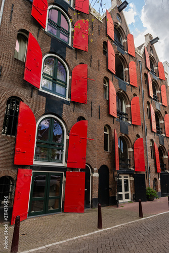 Historic Dutch brick building with red shutters in Amsterdam