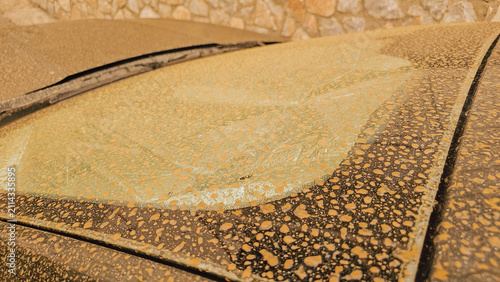 Close up of car windshield covered in orange African Saharan dust dried rain drops after severe sandstorm in Crete Greece for apocalyptic weather stock photo